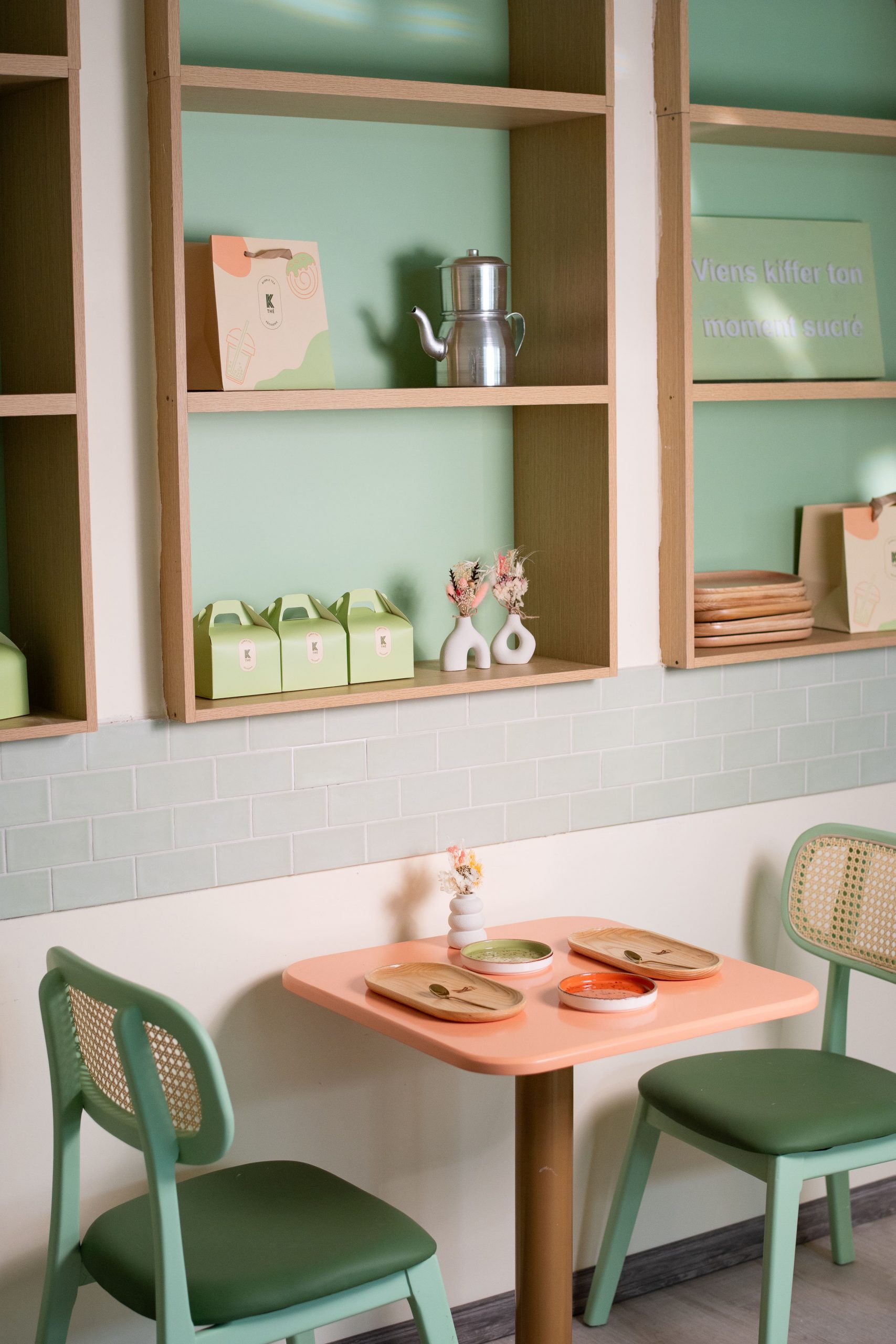 Intérieur chaleureux d’un coffee shop à Saint-Jean-de-Luz avec grand olivier, mobilier bois et ambiance végétale